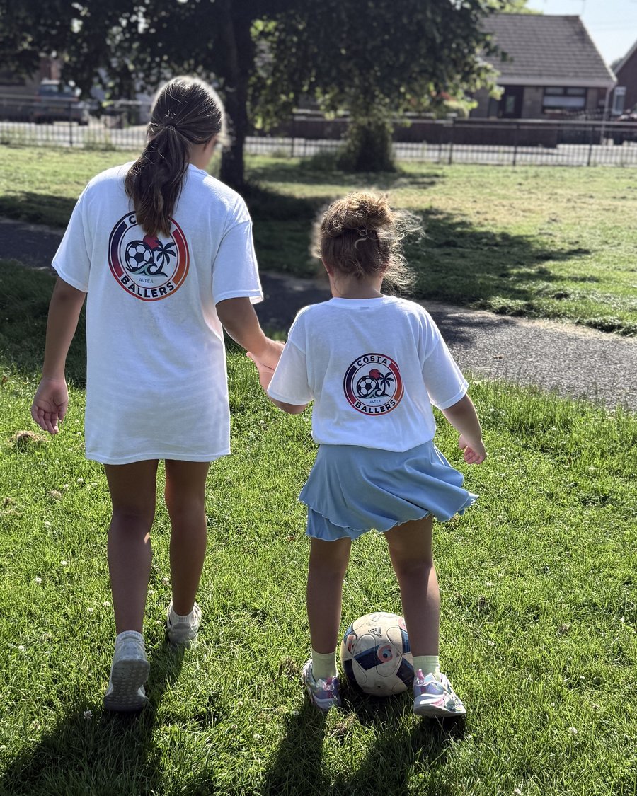 Coach walking hand-in-hand with a young player, offering one-to-one support