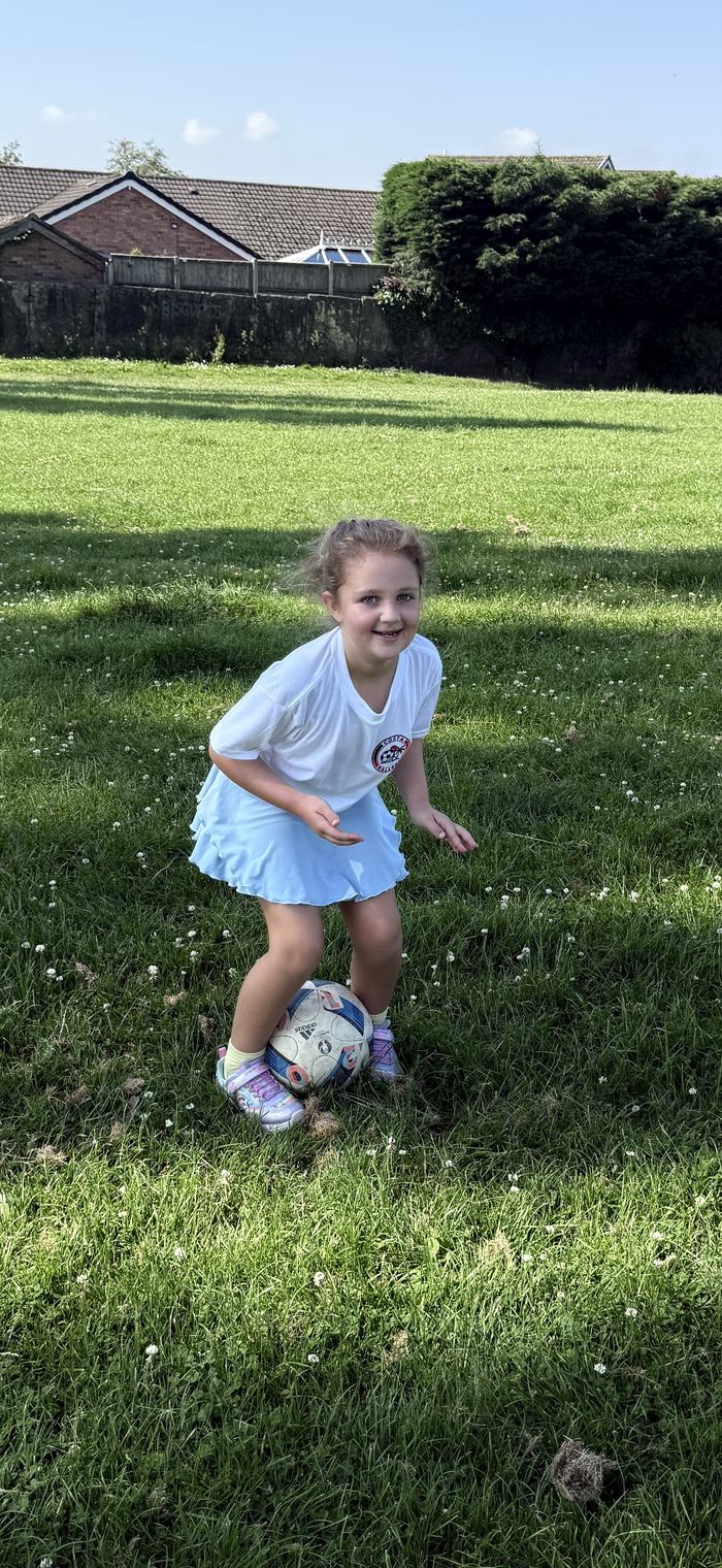 Determined young player dribbling the ball on the pitch