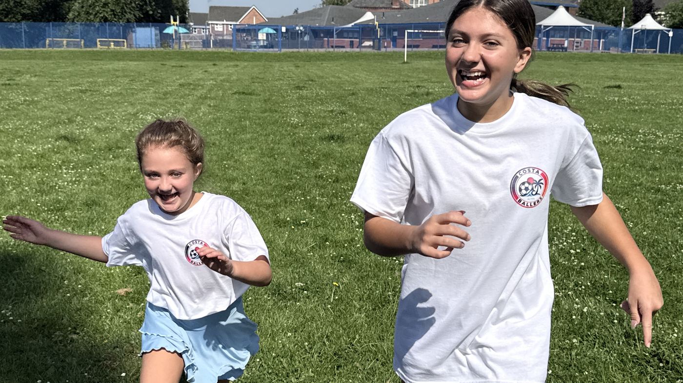 Children running and laughing together during a Costa Ballers football session